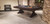 Otis Slate Pool Table by Plank & Hide in Smokehouse finish, shown in a 3/4 angled lifestyle shot at High Point Market in North Carolina, featured in a designer trade show setting with professional lighting and styled vignettes to highlight its modern farmhouse appeal and craftsmanship

