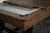 Full 3/4 view of the Nixon Billiards Hunter Pool Table in Brushed Walnut with black metal legs, showcasing the dining top in place. This lifestyle shot highlights the table's ability to function as both a stylish pool table and a sophisticated dining table.

