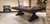 Otis Slate Pool Table by Plank & Hide in Smokehouse finish, shown in a 3/4 angled lifestyle shot at High Point Market in North Carolina, featured in a designer trade show setting with professional lighting and styled vignettes to highlight its modern farmhouse appeal and craftsmanship

