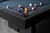The Jackie's Pool Table by Doc & Holliday features luxurious leather pockets, adding a touch of sophistication to its modern black finish. Made in the USA and fully customizable, exclusively at Sawyer Twain.