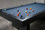 The Jackie's Pool Table by Doc & Holliday features luxurious leather pockets, adding a touch of sophistication to its modern black finish. Made in the USA and fully customizable, exclusively at Sawyer Twain.
