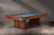The Jackie's Pool Table in Pecan Bourbon Walnut offers stunning craftsmanship and a rich finish. Fully customizable to suit your style, made in the USA by Doc & Holliday, exclusively at Sawyer Twain.