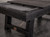 A dynamic 3/4 angle shot of the Isaac Slate Pool Table in Distressed Black & Gold with the optional dining top installed. The table is shown with balls arranged on the playing surface, highlighting the steel grey Championship felt that provides both a sleek look and a durable, spill-proof surface. This shot captures the versatility of the table, seamlessly transforming from a high-end dining piece to a professional-grade pool table, perfect for any game room or commercial space.