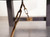 Close-up shot of the brushed gold turnbuckles on the Isaac Slate Pool Table, adding a touch of industrial elegance. The gold finish contrasts beautifully with the Distressed Black wood, showcasing the table's bold, modern aesthetic.