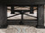 Artful close-up capturing the leather drop pocket, bold leg design, and natural patina of the Weathered Raven finish in a styled interior setting.