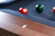 A refined detail shot of the Vancouver Slate Pool Table’s Honey Ash rail, featuring custom inlaid mother-of-pearl diamond sights. This close-up captures the shimmer and polish of the diamond markers, a subtle nod to precision gameplay and luxury craftsmanship. An ideal feature for design lovers and serious players seeking “custom pool tables with mother-of-pearl diamond sights” or “high-end billiard rail detailing in contemporary finishes.”