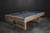 3/4 view of the Bryant Slate Pool Table by Nixon Billiards in a beautifully styled game room, showcasing its Weathered Natural finish and sleek rectangular pedestal legs. This lifestyle shot captures the table's blend of rustic charm and modern design, making it the perfect centerpiece for any home.